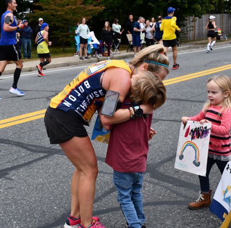 Boston marathon runner hugging child
